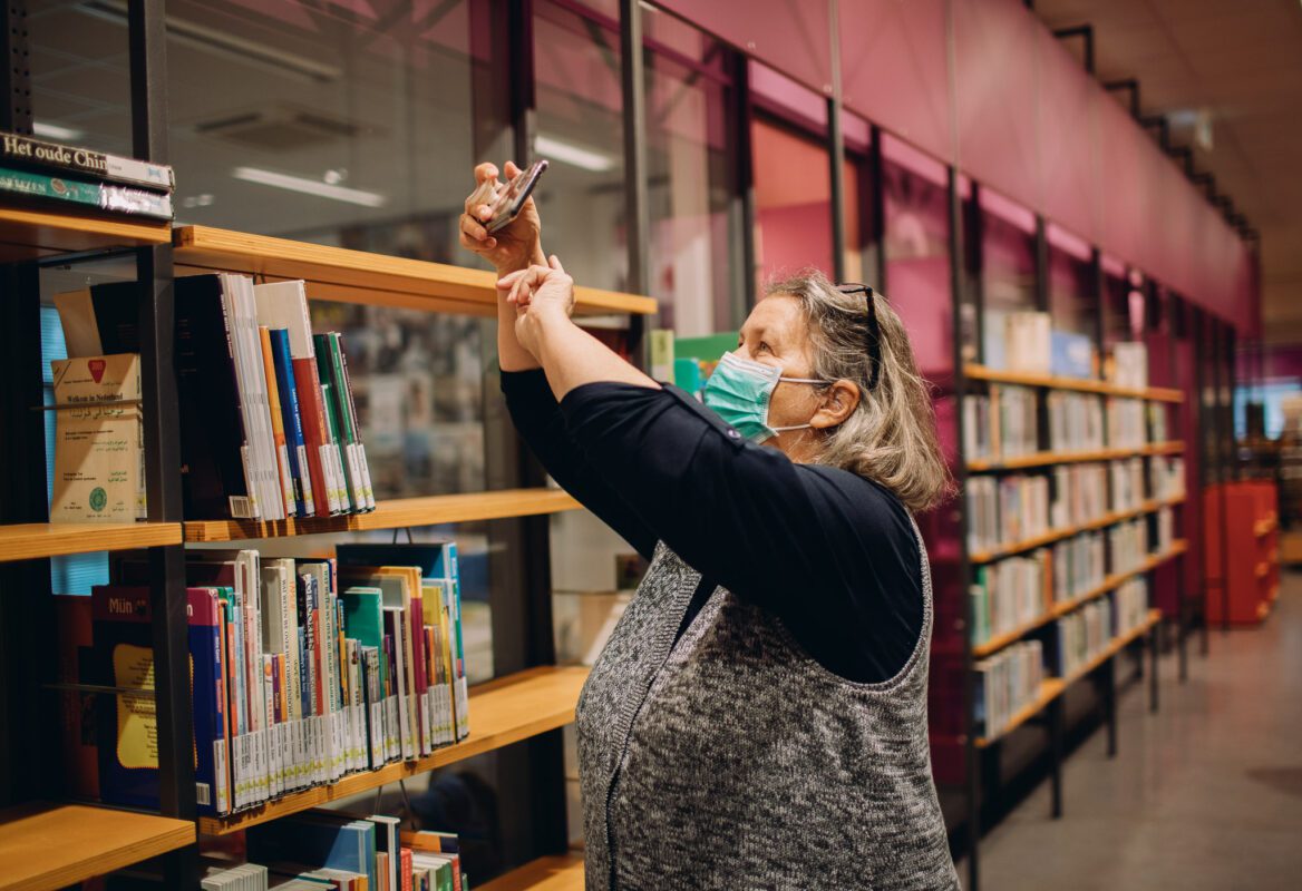 Deelnemer winterschool maakt foto van bibliotheek met mobiel