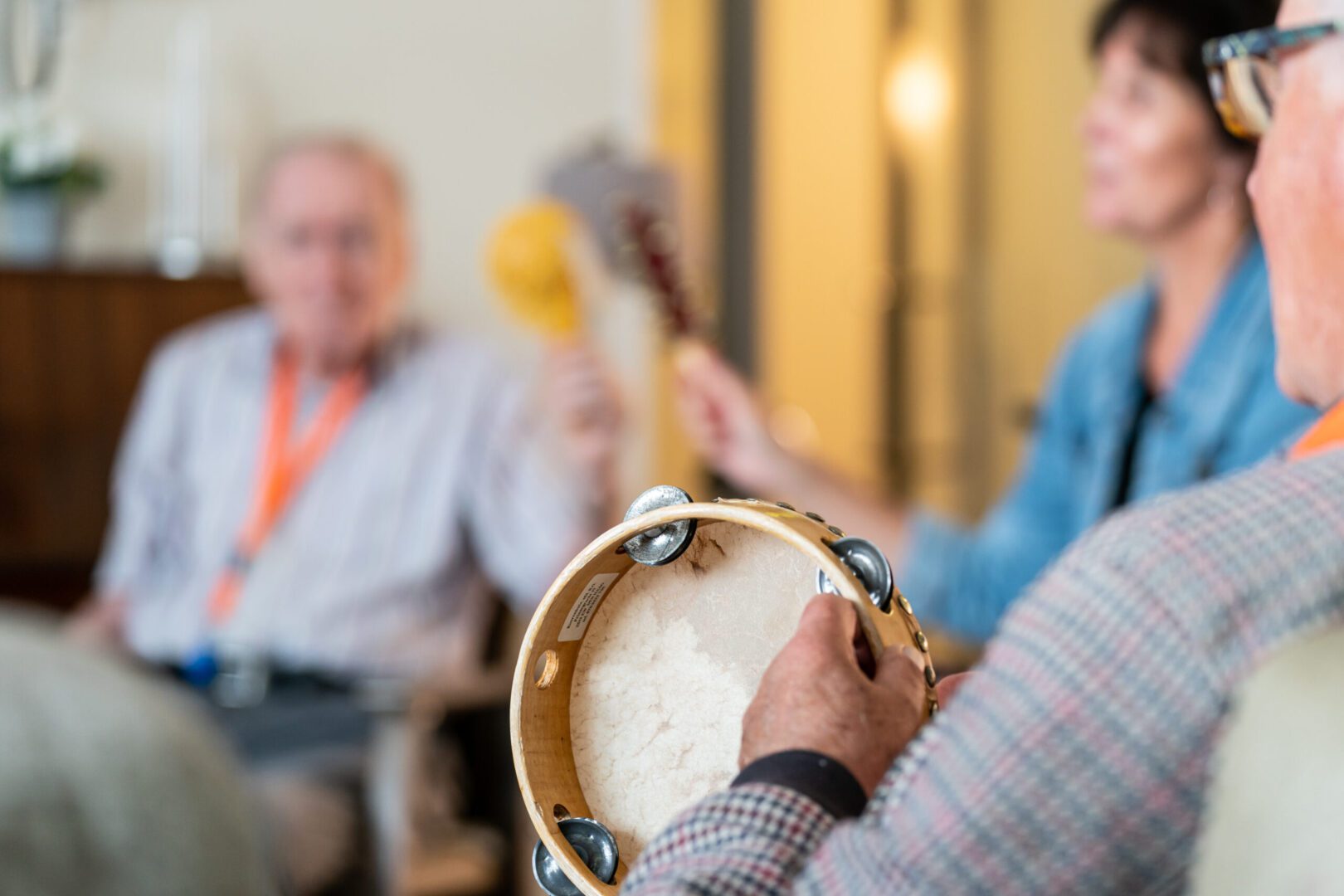 ouderen maken muziek met trommels en rammelaars tijdens kunstknuffel